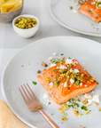 Sockeye Salmon dish with garnishes on a plate, accompanied by a fork, set against a light background.