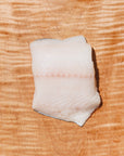 raw black cod on a wooden board