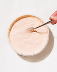 Glass bowl with Cajun smoked salmon dip and a spoon, on a light background