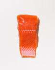 raw coho salmon portion on a white background