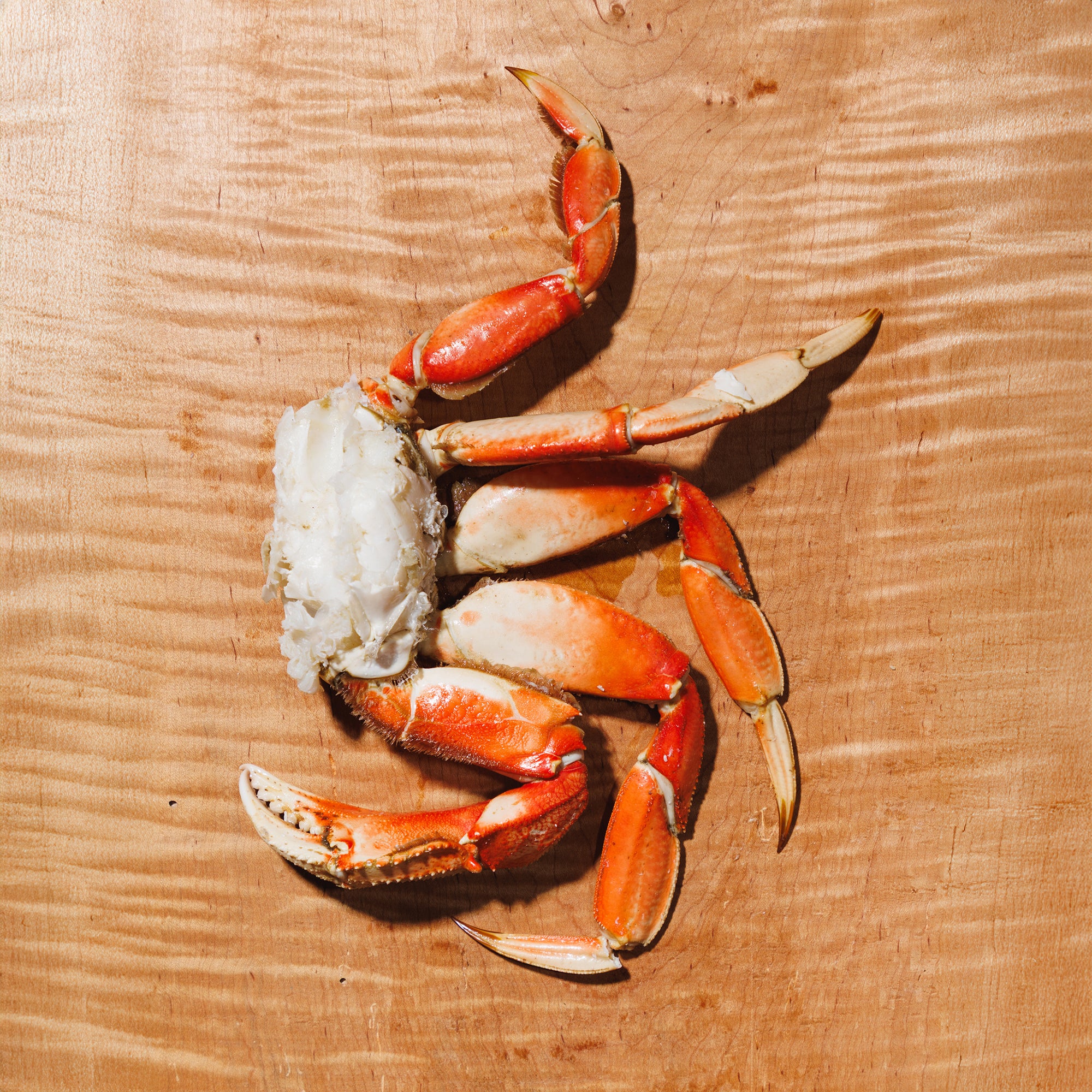 Dungeness crab cluster on a wooden cutting board