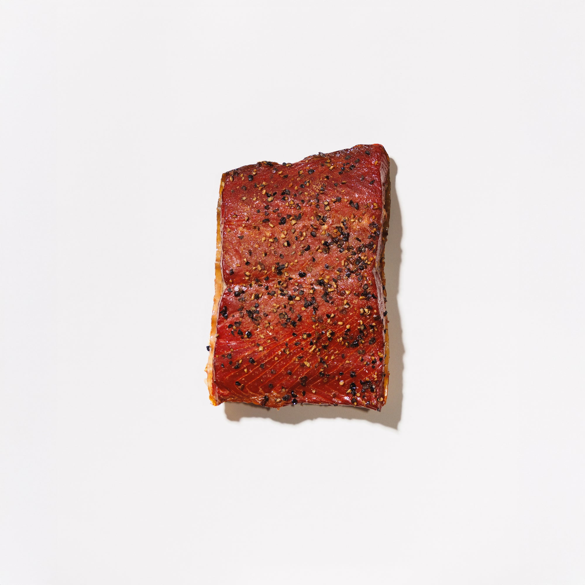 Portion of garlic hot smoked salmon on a white background
