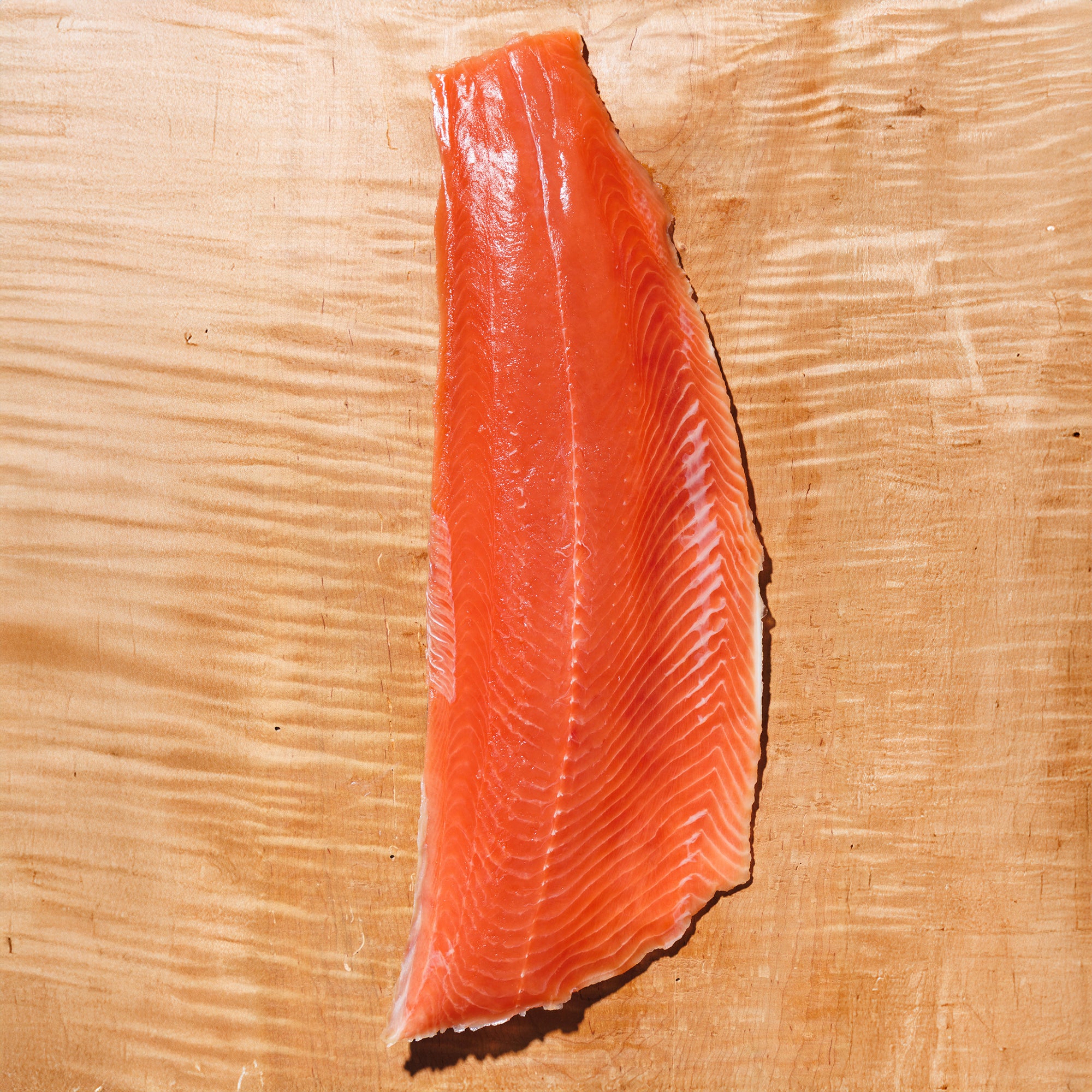 Raw Keta salmon fillet on a wooden cutting board