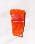 Raw king salmon portion on a white paper background