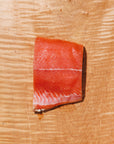 Raw keta salmon fillet on a wooden cutting board