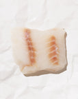 Raw wild ling cod on a white background