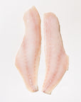 Two raw rockfish fillets on a white background