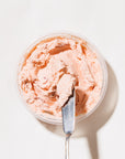 smoked salmon spread with serving knife in container on white background
