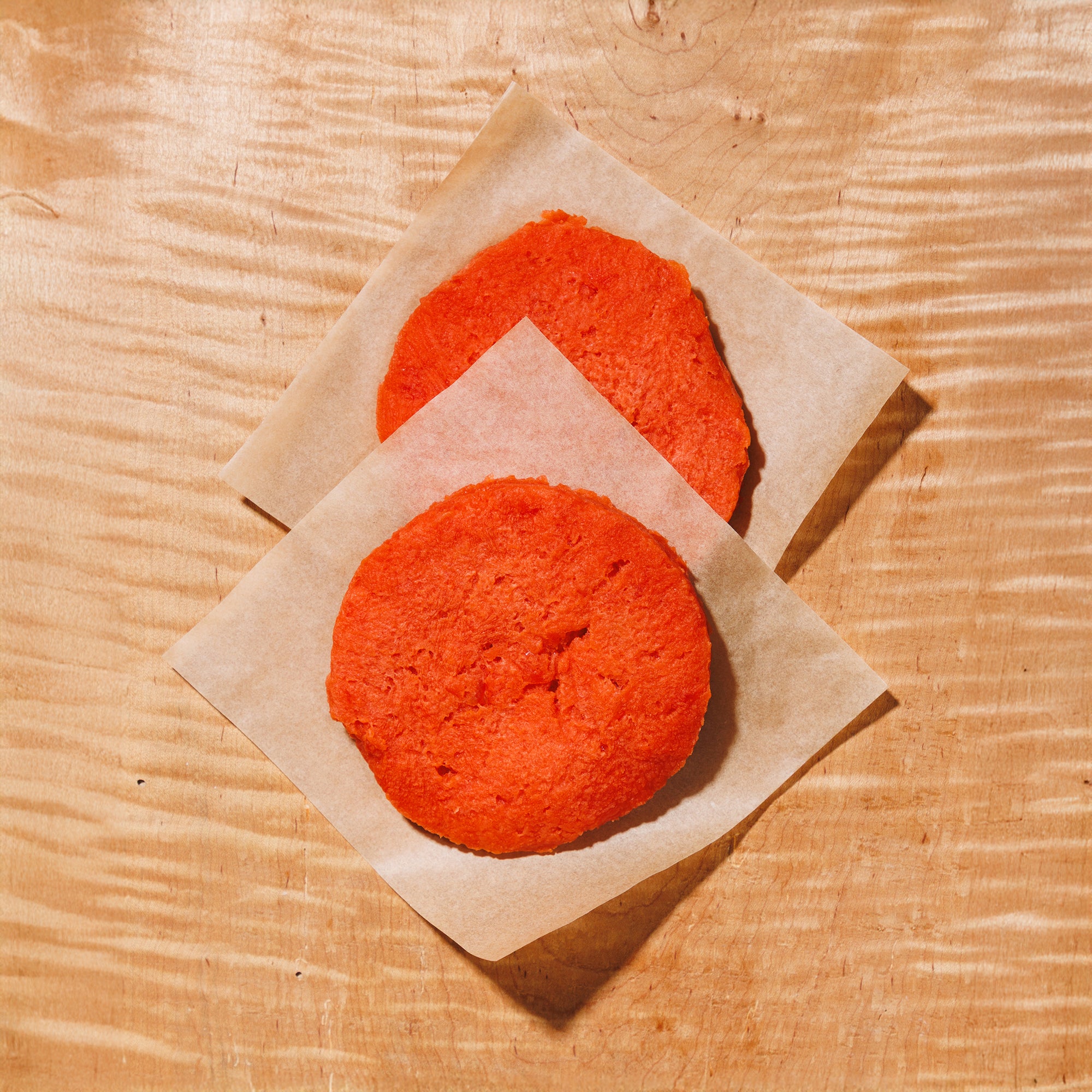 raw sockeye salmon burger patties on a wooden background