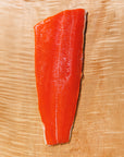 Raw sockeye salmon fillet on a wooden cutting board