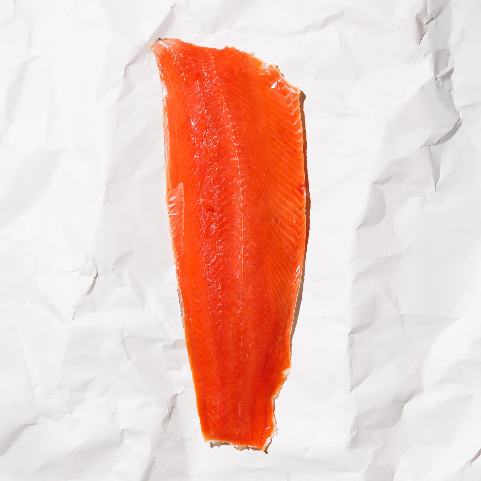 Raw Sockeye salmon fillet on a white paper background