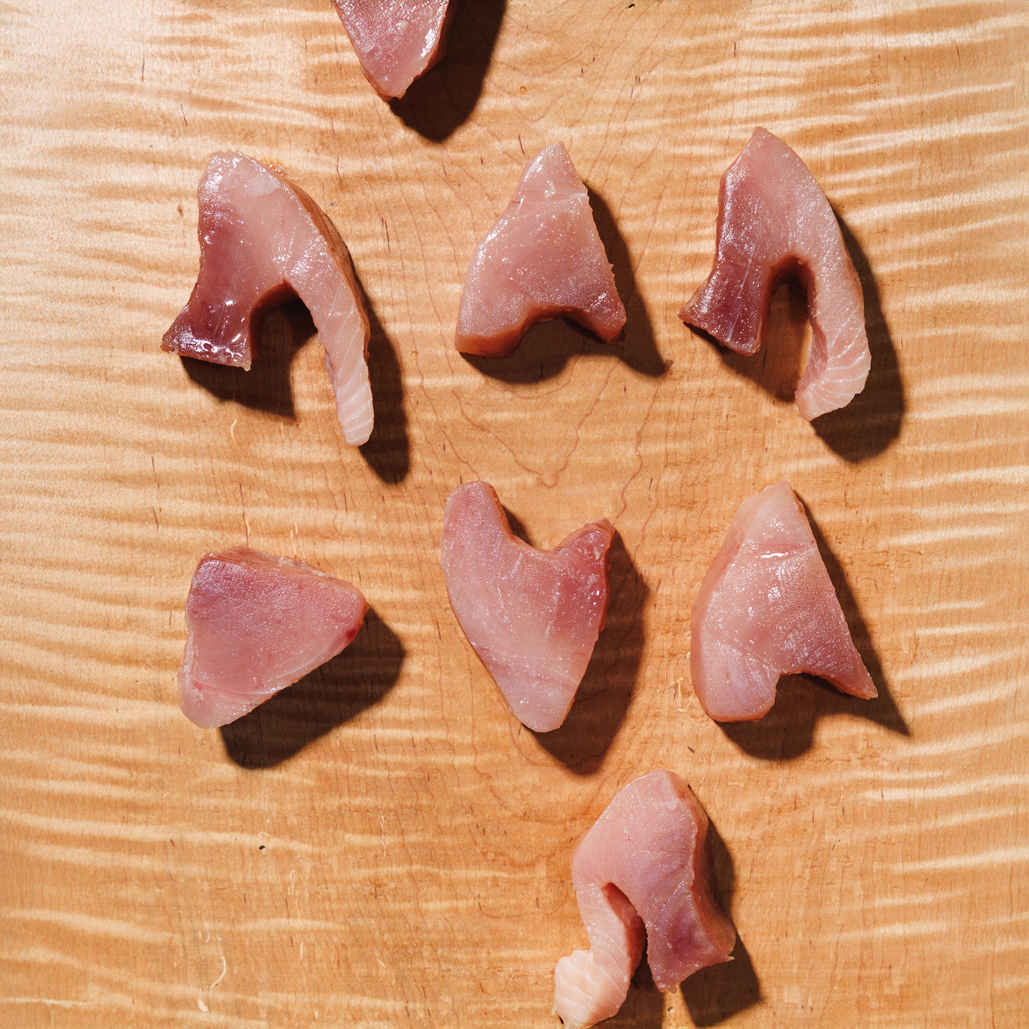 Slices of raw tuna on a wooden cutting board