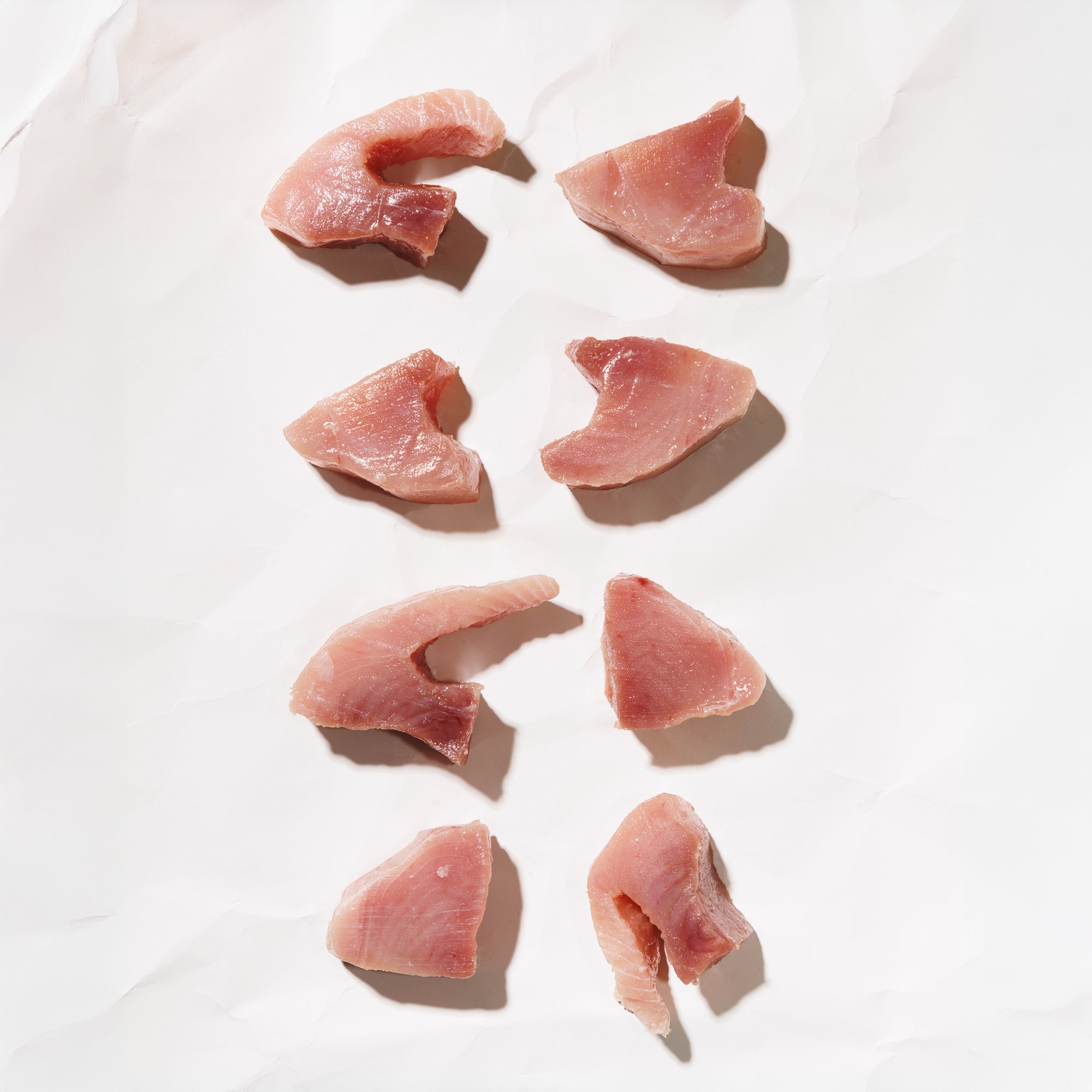 Raw tuna medallions on a white background