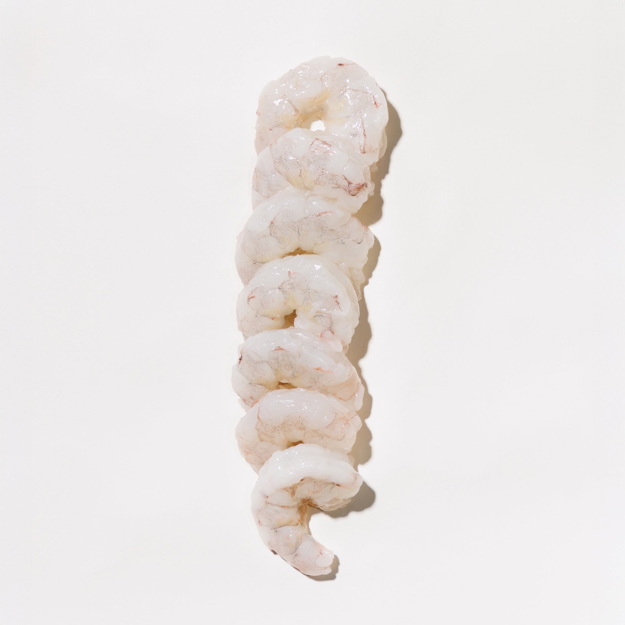 Pile of raw shrimp on a light background