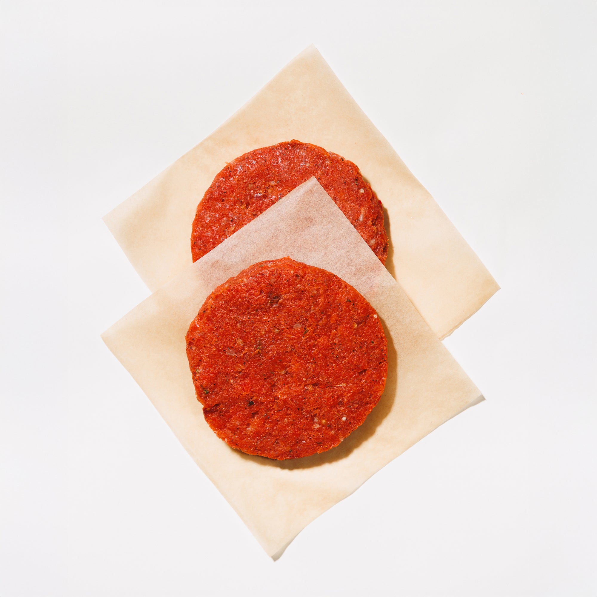 raw sockeye salmon burger patties on a white background