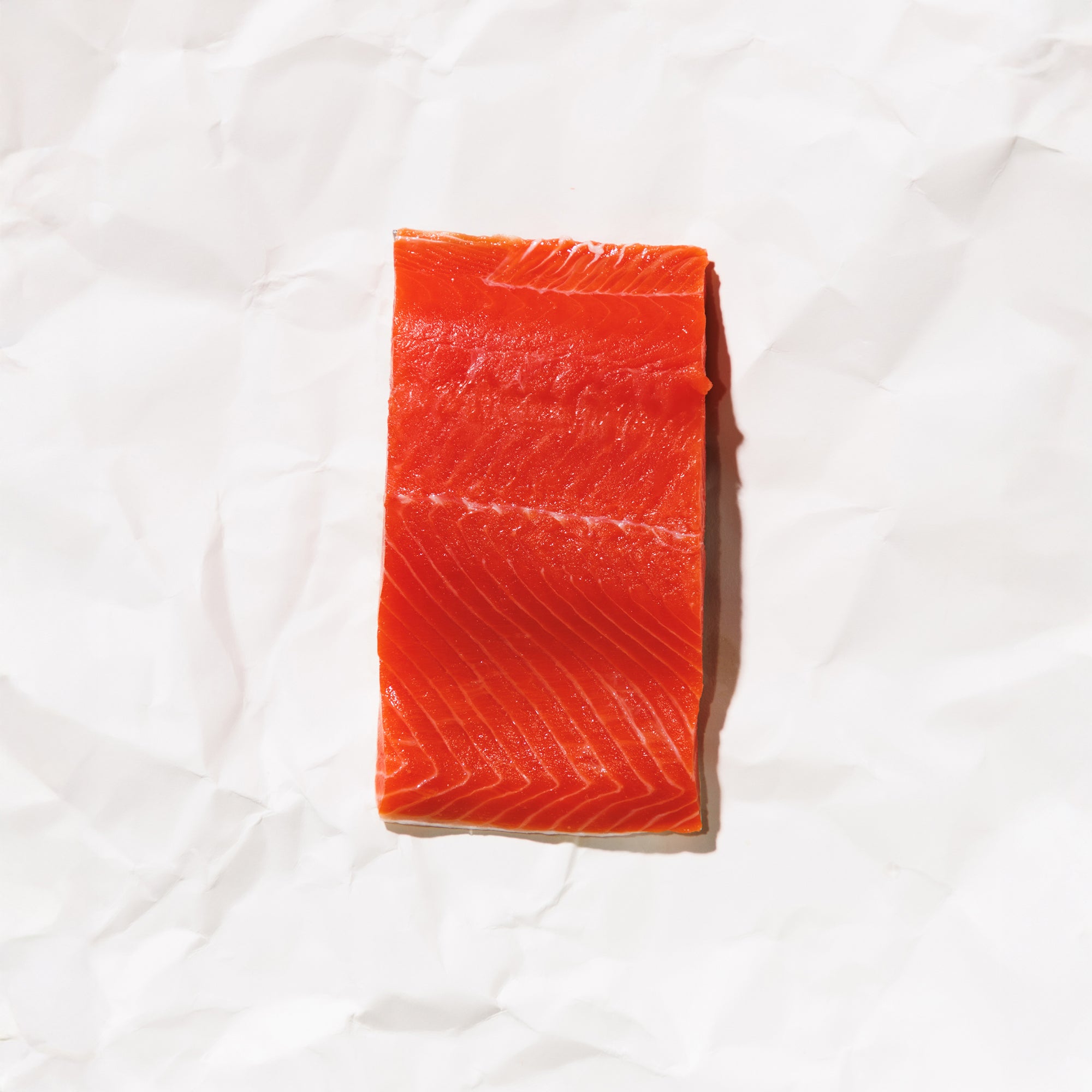 Raw sockeye salmon fillet on a white background