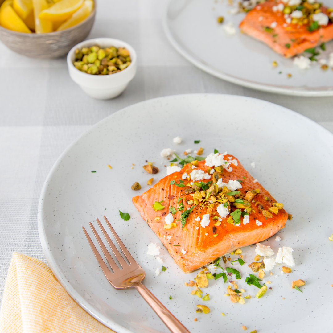 Sockeye Salmon dish with garnishes on a plate, accompanied by a fork, set against a light background.