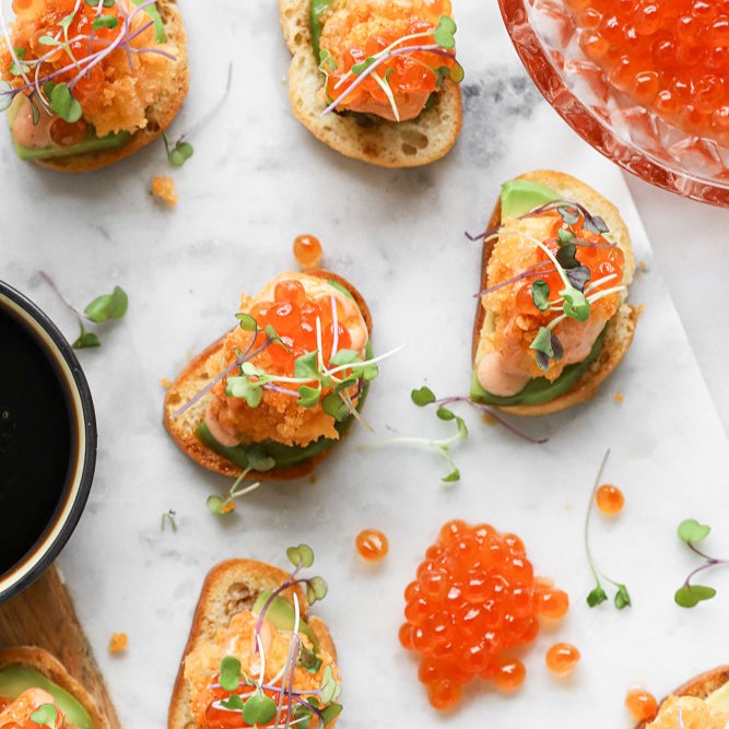 Red Caviar on canapes assored on a marble tray 
