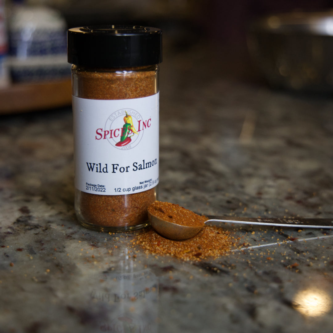 Wild for Salmon Seasoning on a marble counter with some seasoning spilled next to it. 