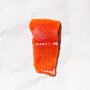 Raw king salmon portion on a white paper background
